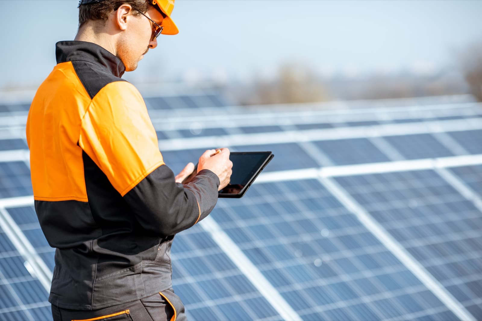 Technik s tabletem kontroluje fotovoltaické panely